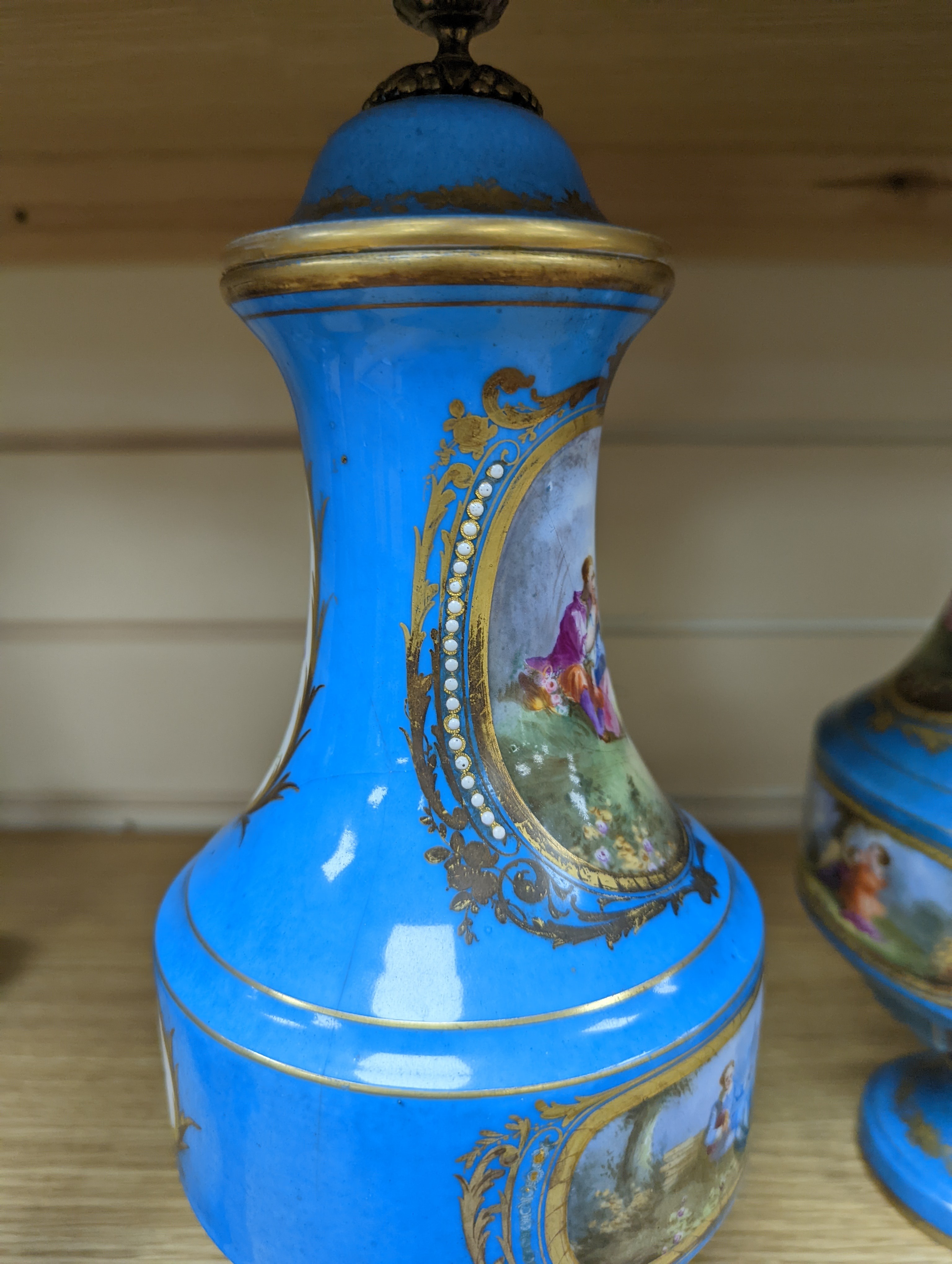 A pair of Sevres style porcelain bleu celeste ground vases and covers, 34cm